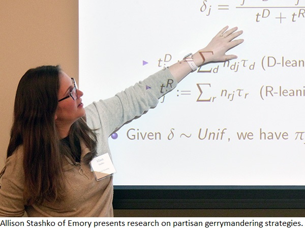 Allison Stashko gestures toward a projection of scientific equations on a screen